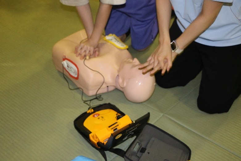 健康科学科の学生からレクチャーを受けながら、中学生もAEDの操作や胸骨圧迫にチャレンジ!
